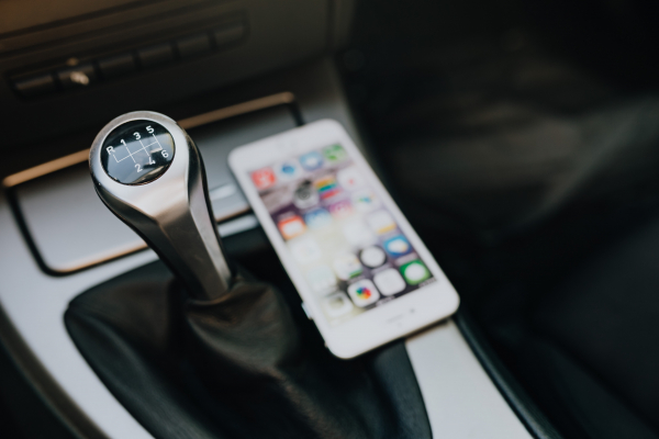 Modern car interior with smart phone on manual gear stick
